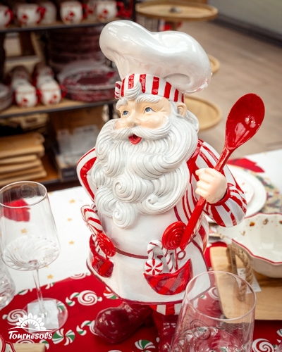 Statue de Père Noël chef cuisinier avec une cuillère rouge dans un marché de Noël.